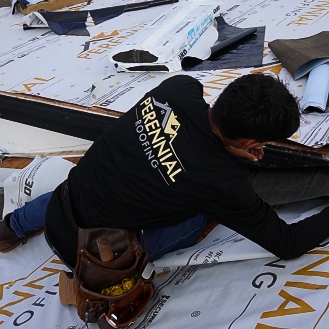 Perennial Roofing crew member hand nailing shingles on a roof